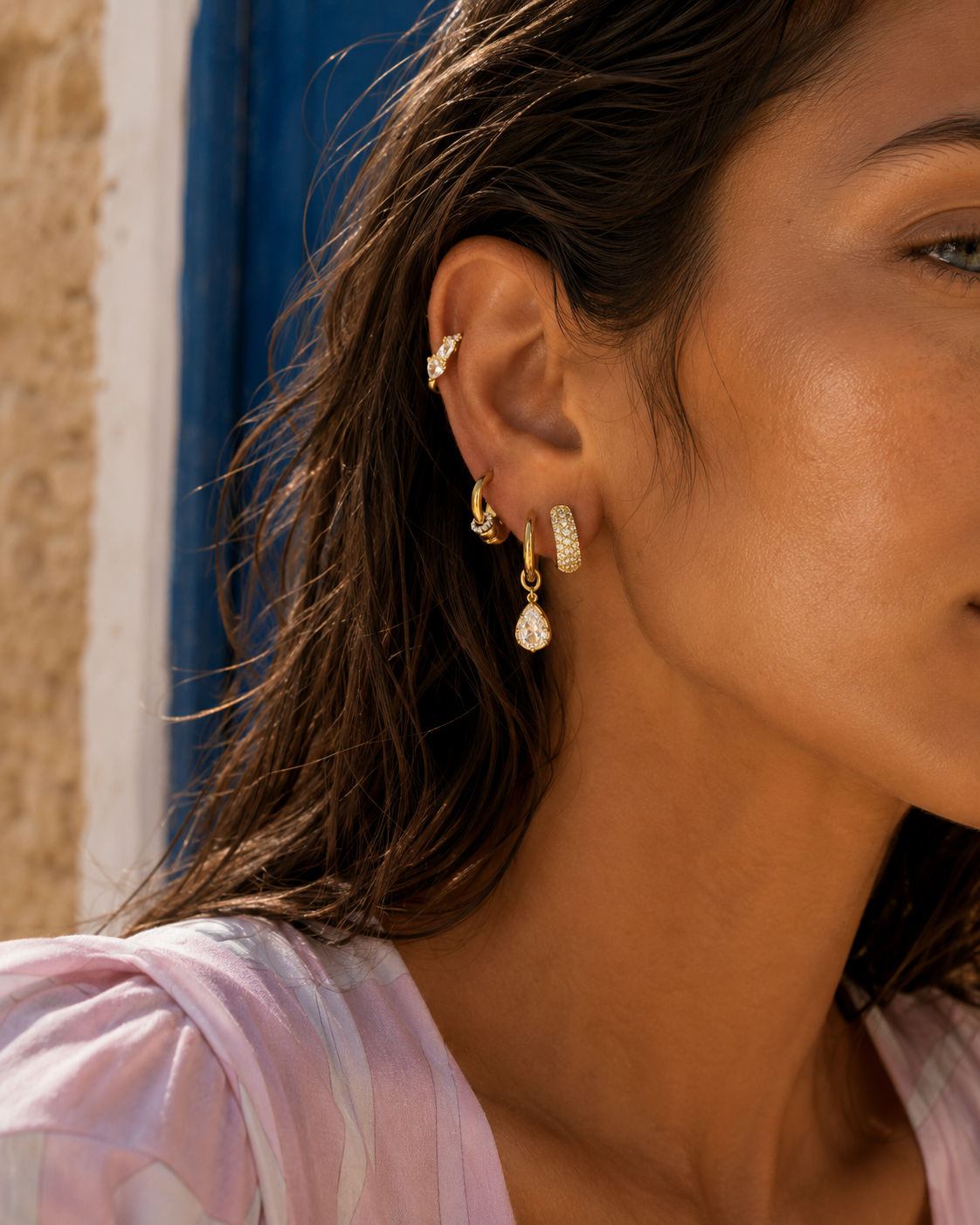 Classy gold ear stack with huggies, studs and multiple lobe and cartilage piercings.
