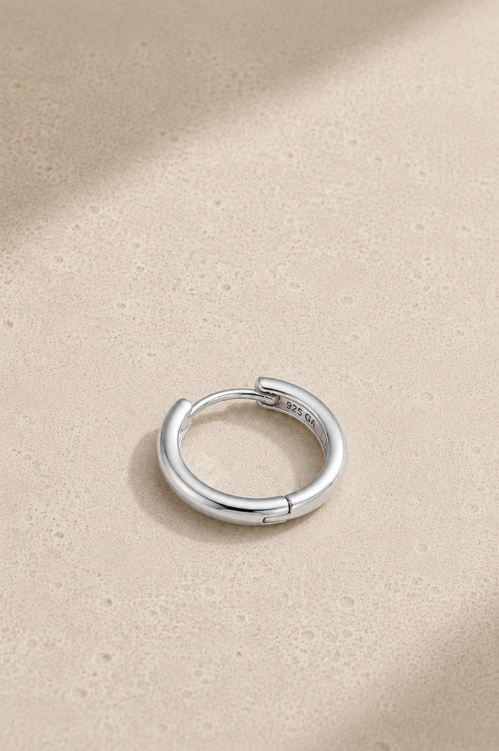 Polished silver hoop huggie earring for lobe and conch piercings standing upright