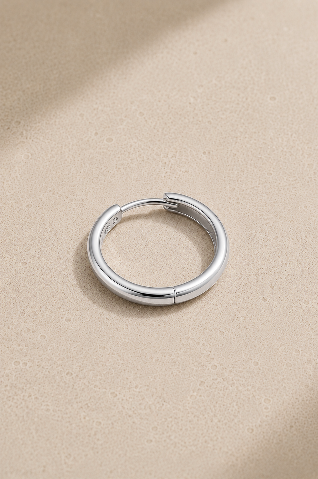 Polished silver hoop huggie earring for lobe and conch piercings standing upright