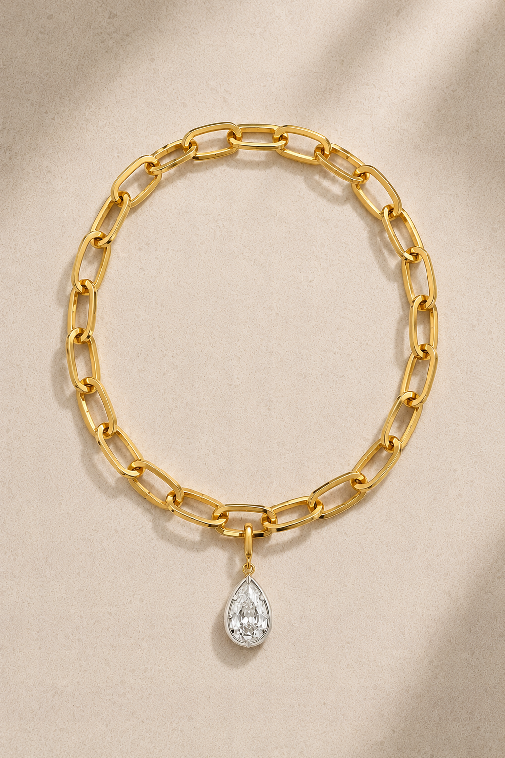 Cara chunky gold bracelet with mixed-metal Vittoria crystal charm on beige background