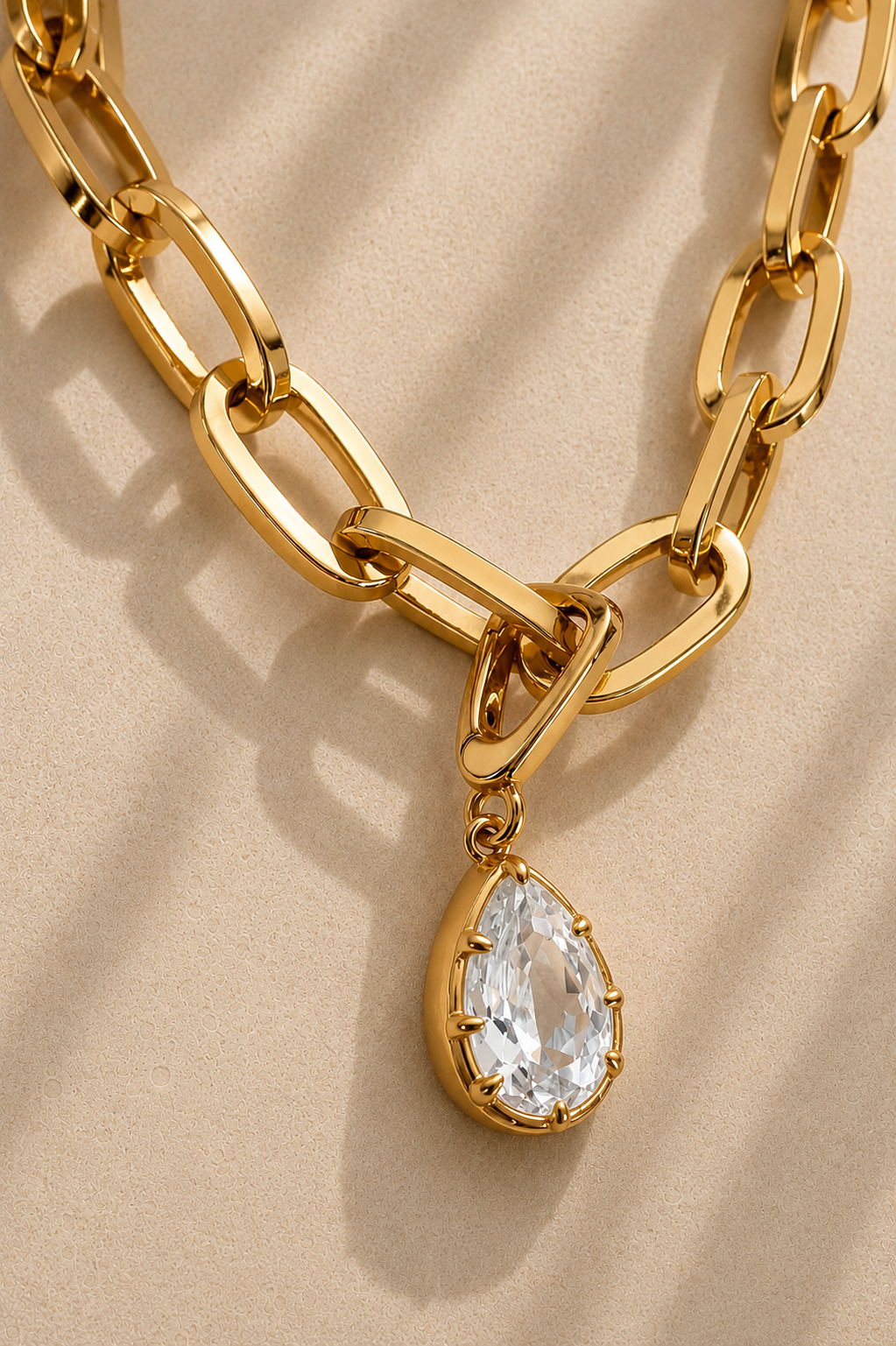 Close-up of oversized gold paperclip chain with Vittoria gold teardrop crystal charm