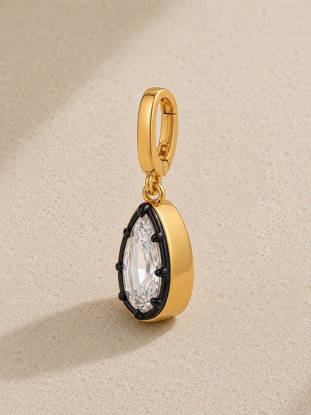 Gold and black rhodium teardrop crystal hook charm hanging from signature clasp