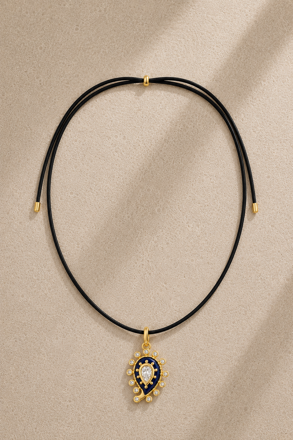 Black adjustable cord necklace with lapis paisley evil eye charm on beige background