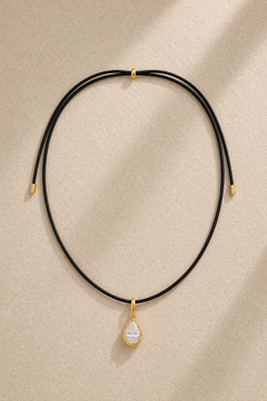 Close-up of Vittoria gold teardrop crystal charm hanging on adjustable black cord necklace