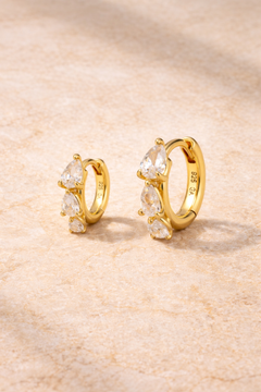 Double ear piercing gold huggie set with 6.5mm and 8.5mm cascade graduated pear cut cubic zirconia