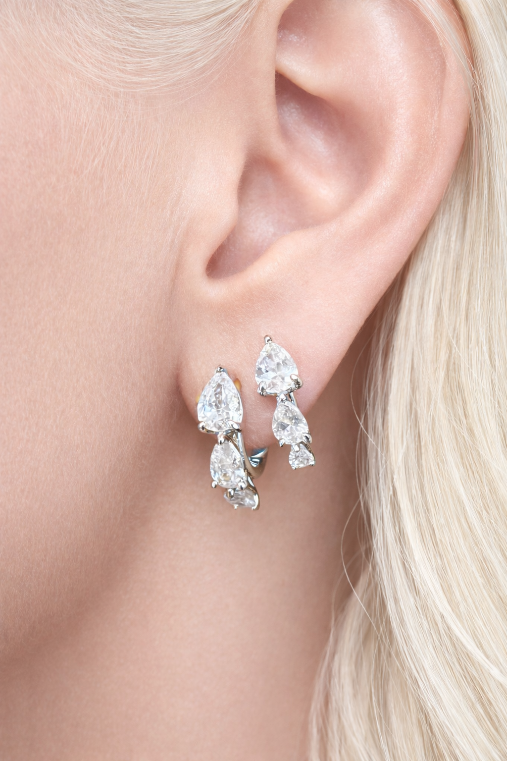 Two earrings in one ear styling with cascade silver huggies for second ear piercings and modern ear stacks