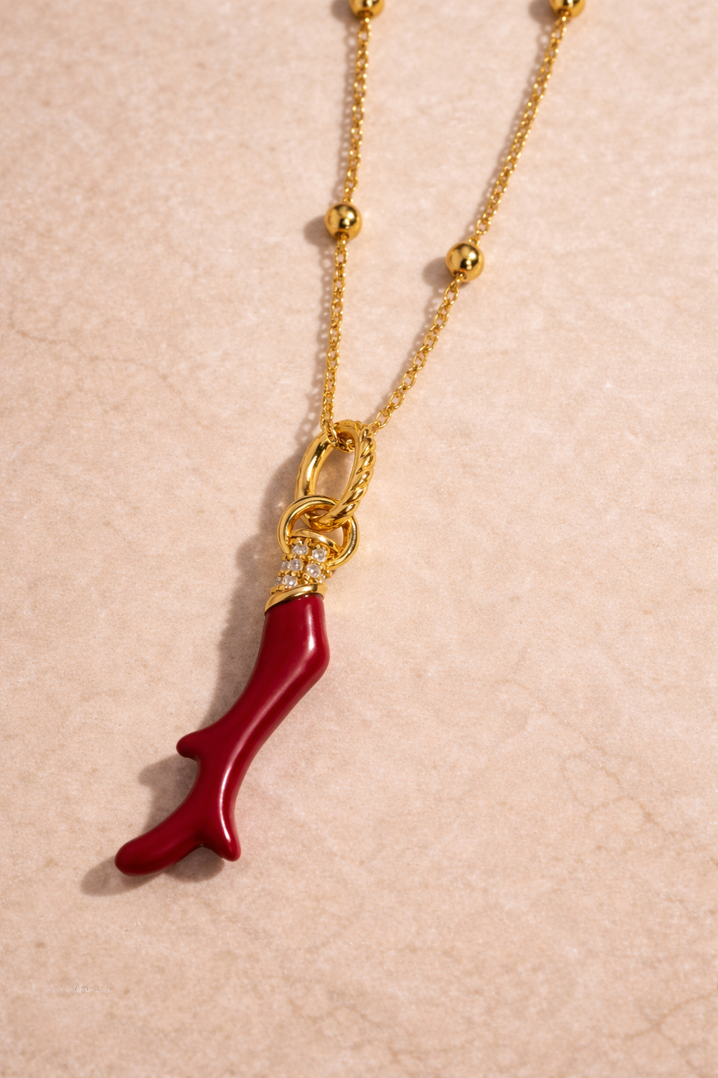Close-up of Speira red coral gold vermeil charm in 925 sterling silver with 18ct gold plating and white CZ pavé detailing