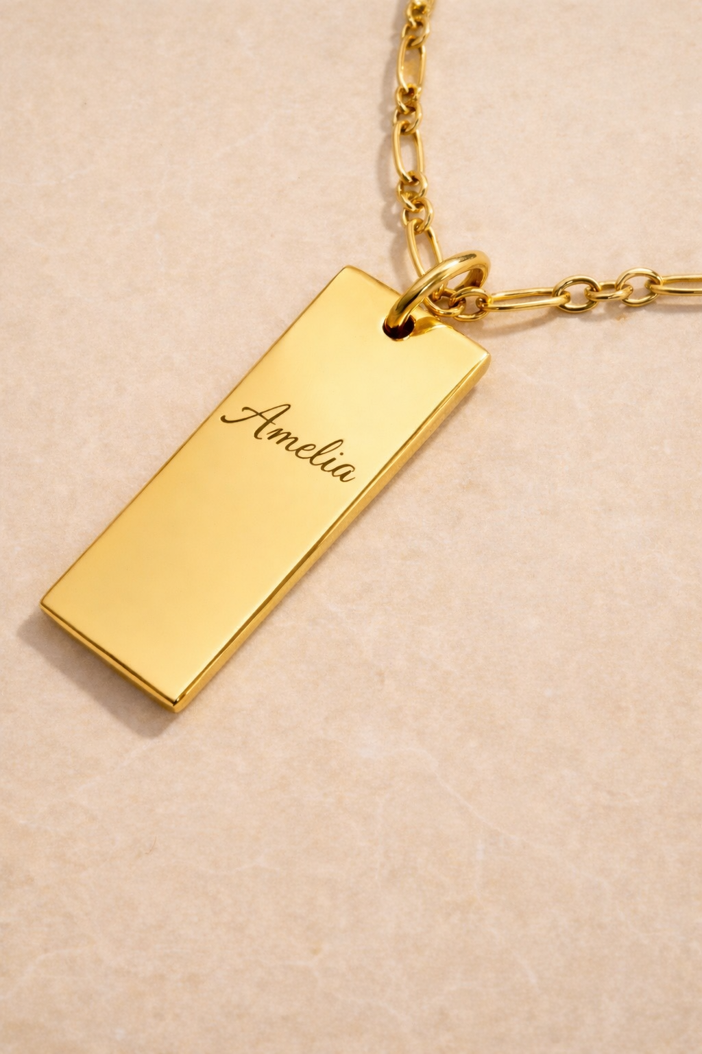 Close-up of engraved medium dog tag pendant in gold vermeil – name engraving detail
