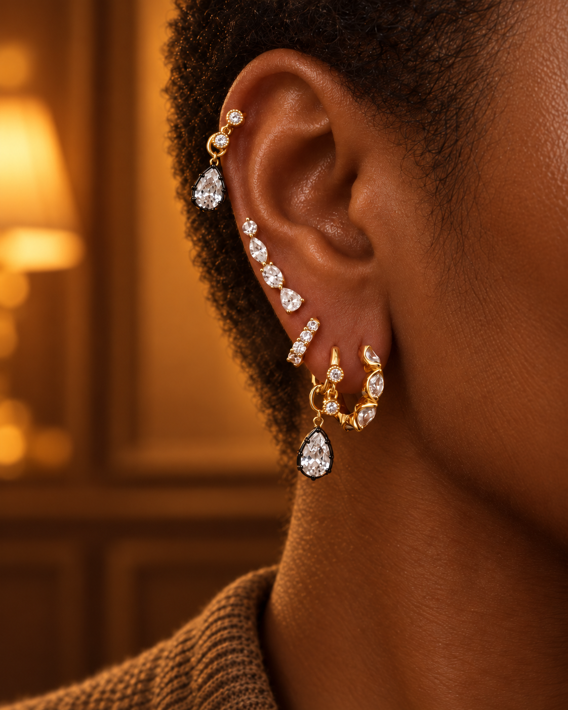 Full gold ear stack by Galleria Armadoro featuring the 11 mm Tasha Marquise, Riviera ear crawler, Simple Shaker huggies and black rhodium Vittoria teardrop charms.