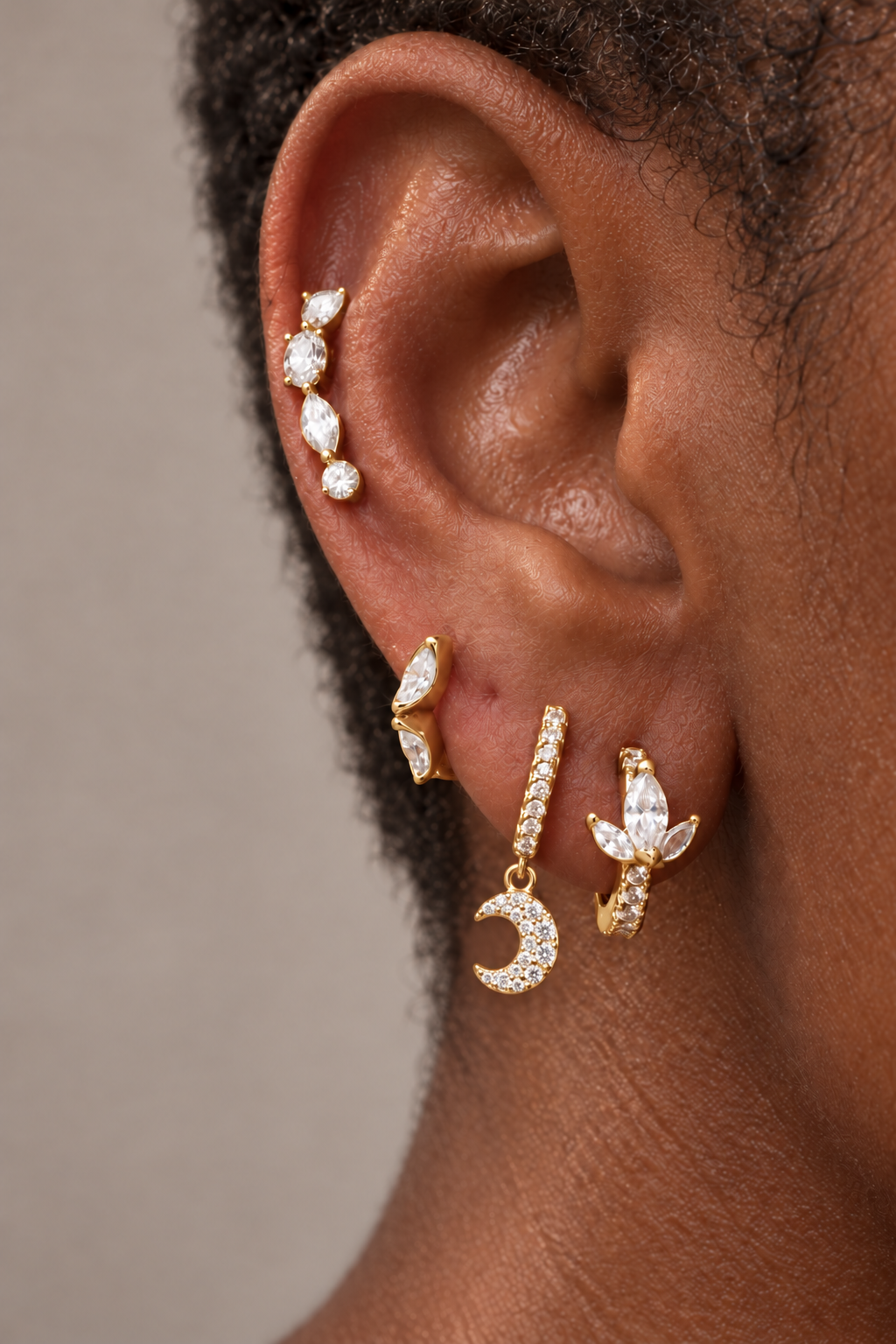 Four-piece gold ear stack by Galleria Armadoro featuring crystal studs, a pavé charm huggie and statement gemstone hoops.