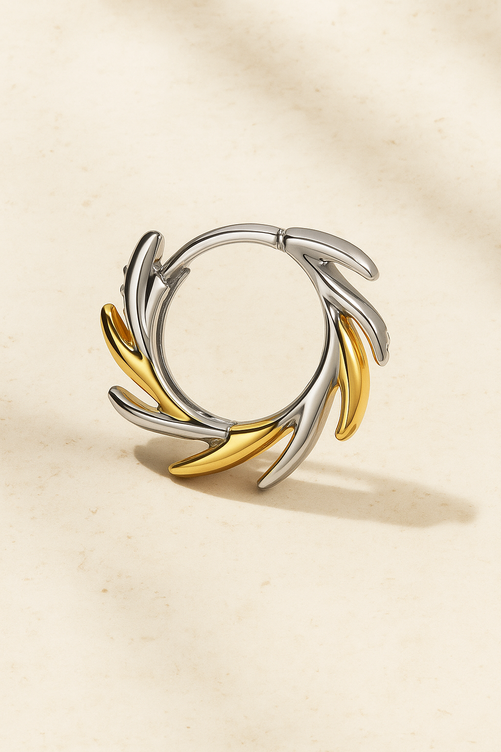 Elara Two-Tone Huggie Earring close-up showing pavé detailing and alternating gold and silver leaf-like curves.
