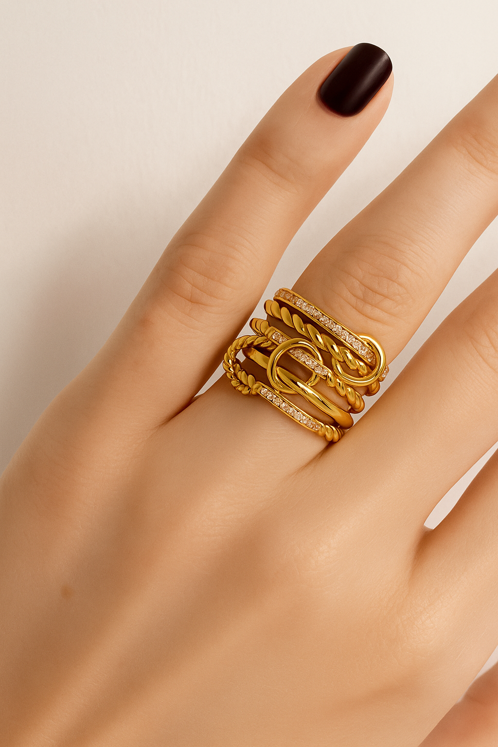 Livia ring components – twisted rope band and pavé circle charm linked together, floating on beige backdrop.