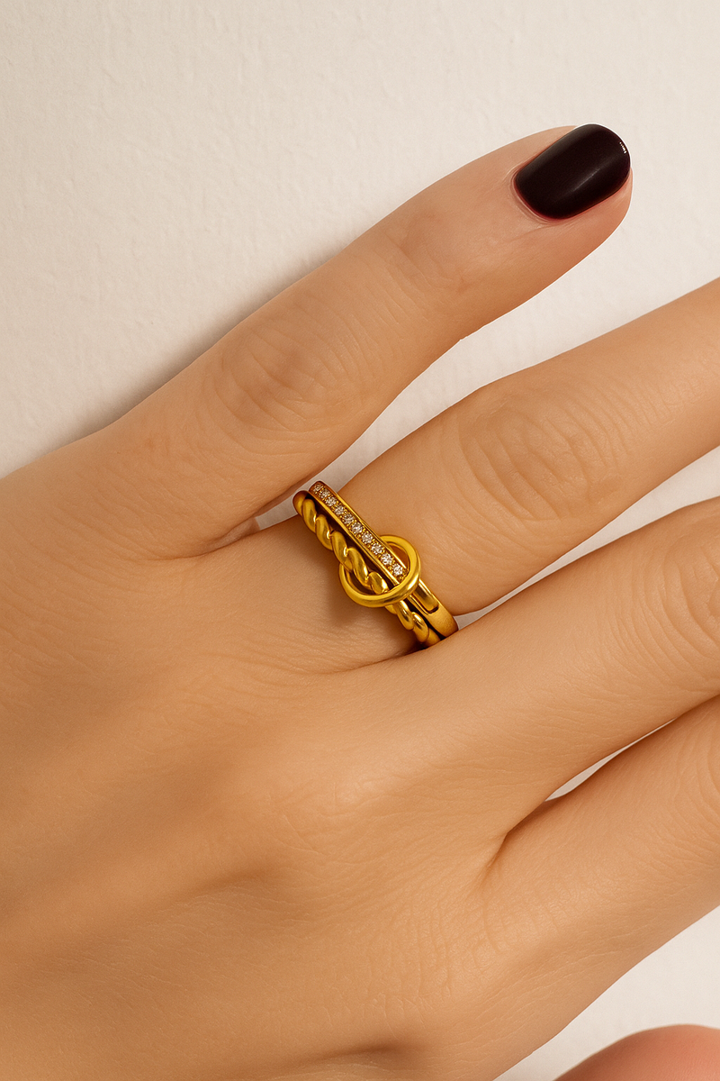 Editorial hand shot featuring multiple mixed-metal rings including the two-tone Livia.