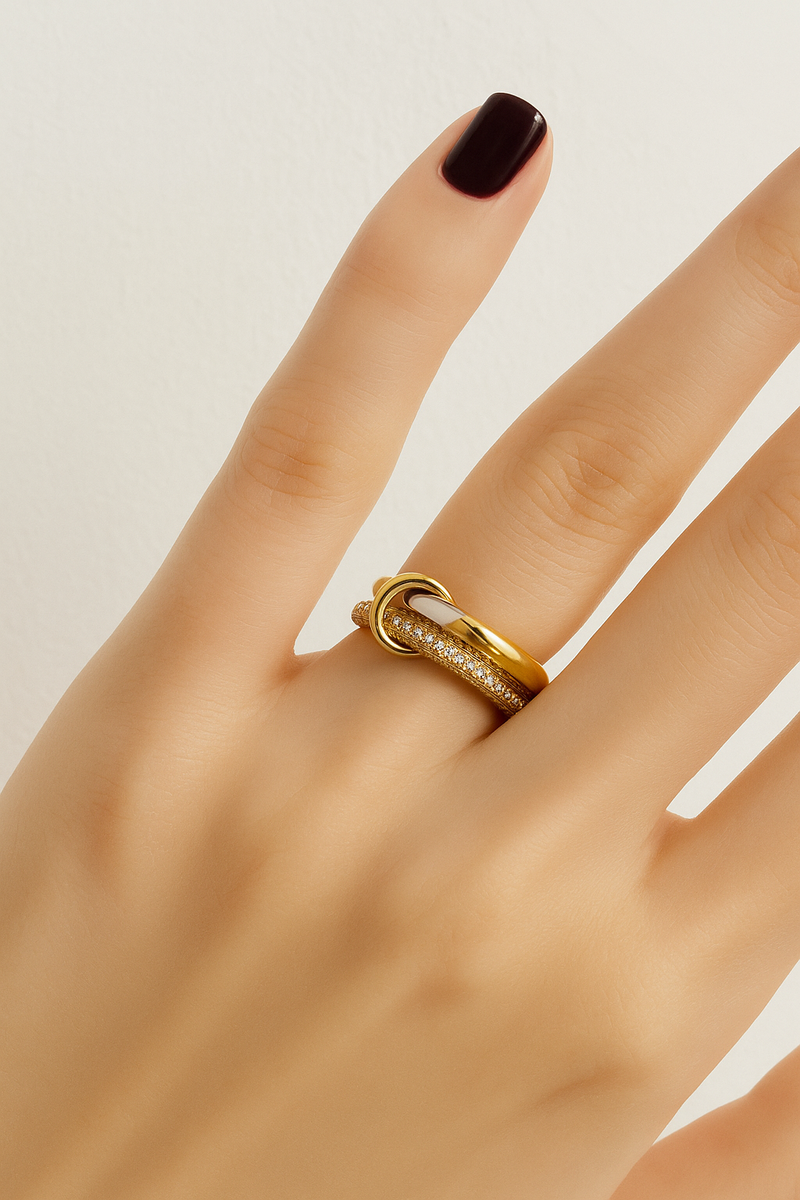 Nora Speira two-tone linked pavé ring worn on finger with deep burgundy manicure.