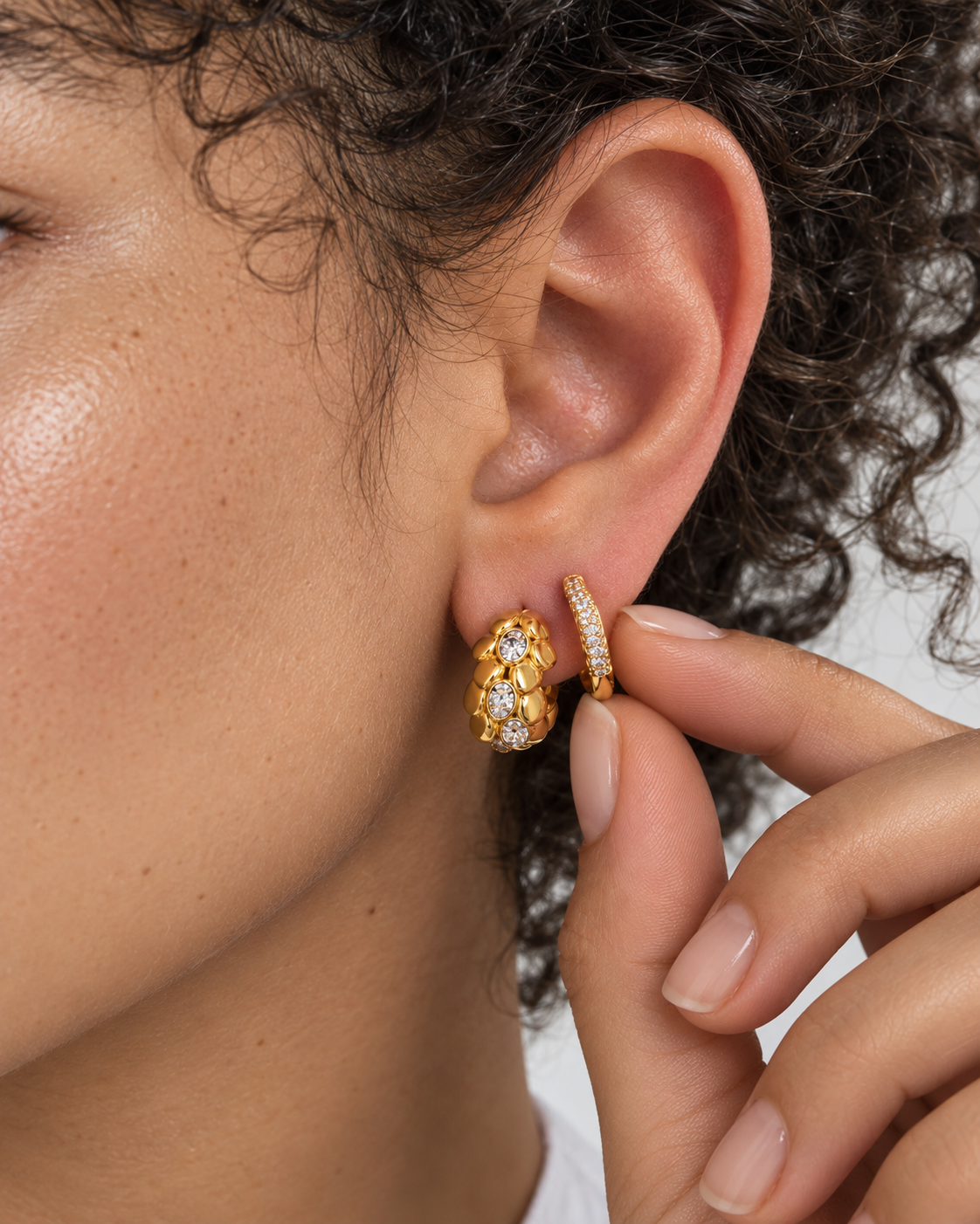Gold second ear piercing stack by Galleria Armadoro featuring the sculptural Leona earring paired with the pavé Aurora Kyma huggie.