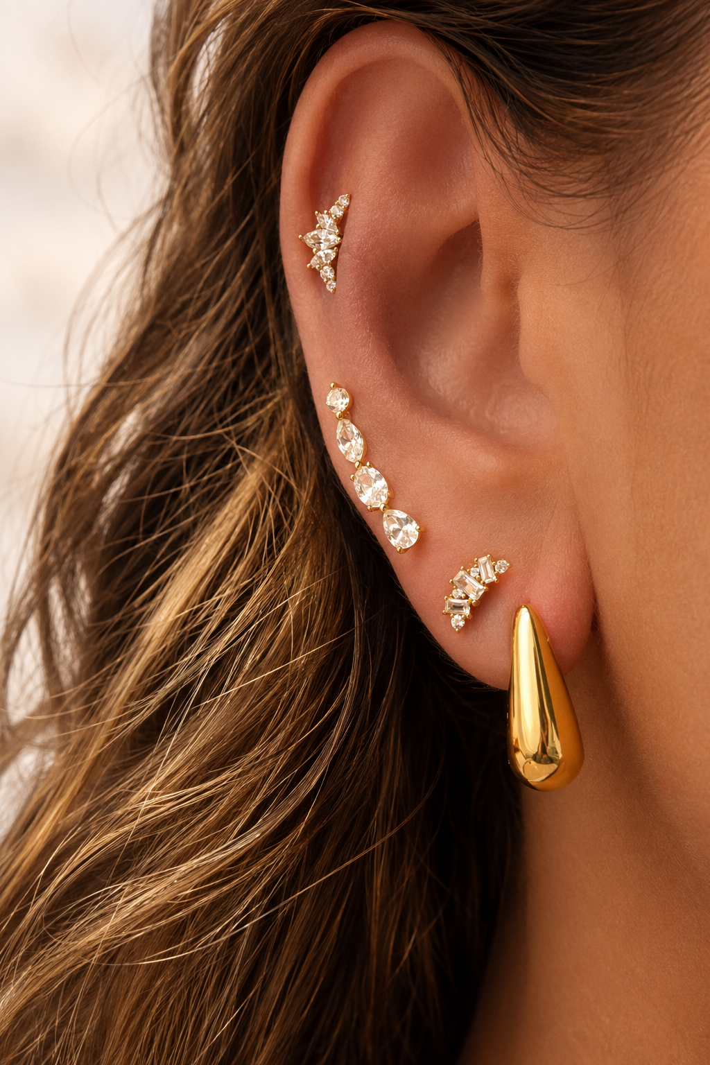 Gold ear stack by Galleria Armadoro featuring the sculptural Bella Hoop and Yasmin with delicate crystal ear jewellery.