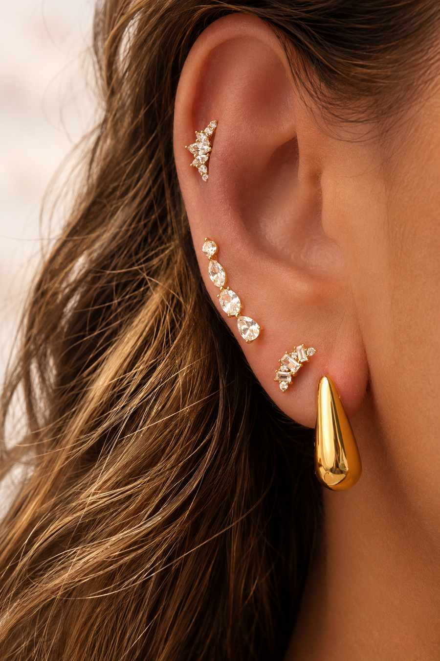 Gold ear stack by Galleria Armadoro featuring the sculptural Bella Hoop and Yasmin with delicate crystal ear jewellery.