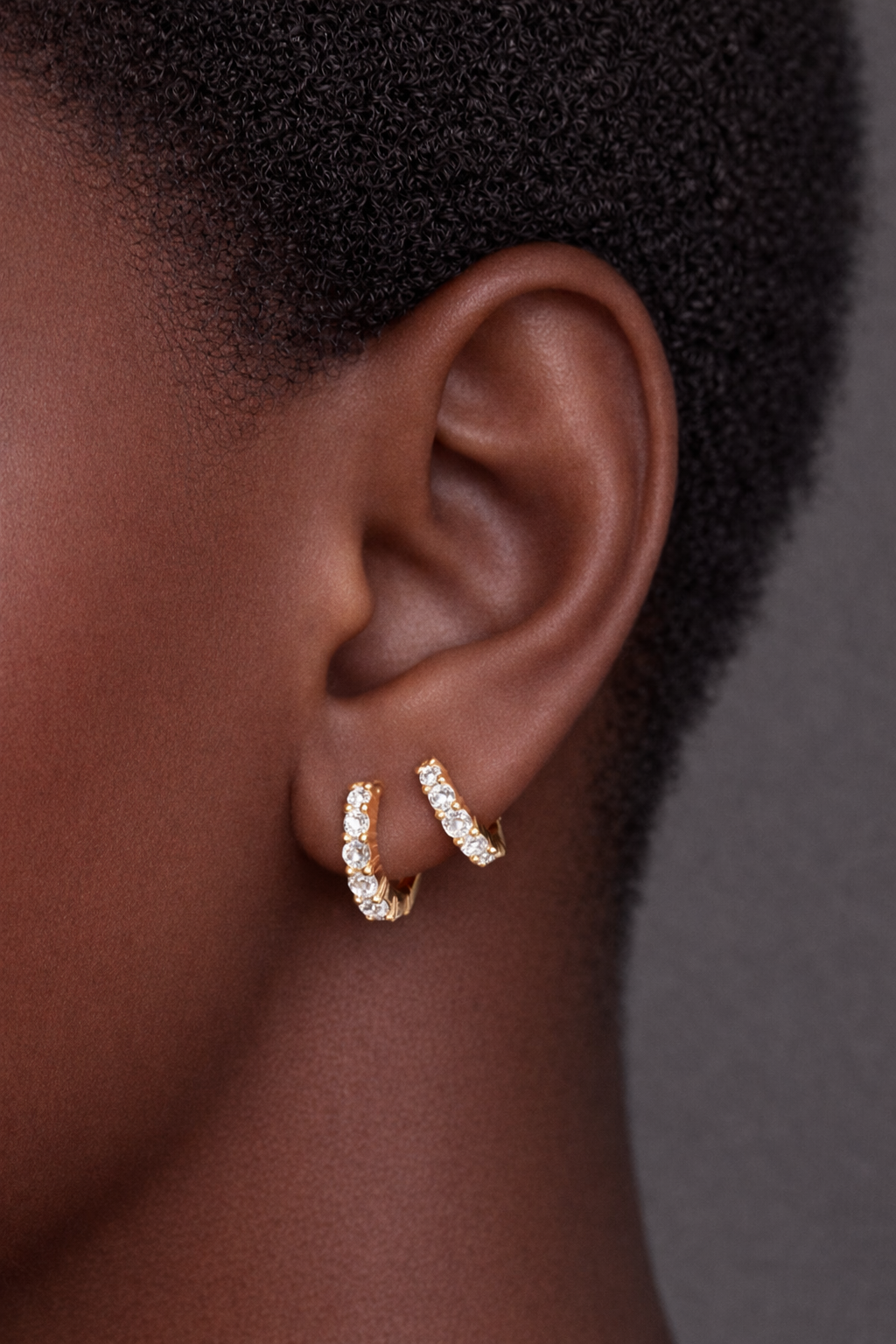 Two earrings in one ear styling with jumbo graduated gold huggies for second ear piercings