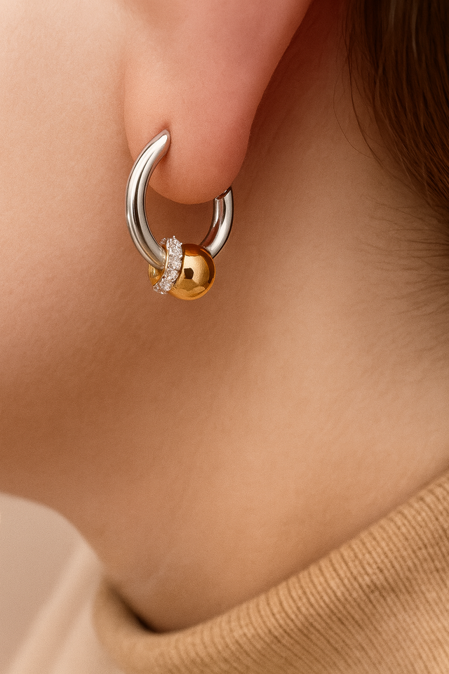 Kora two-tone bead huggie earring worn in lobe piercing, mixed silver and gold with sparkling CZ halo