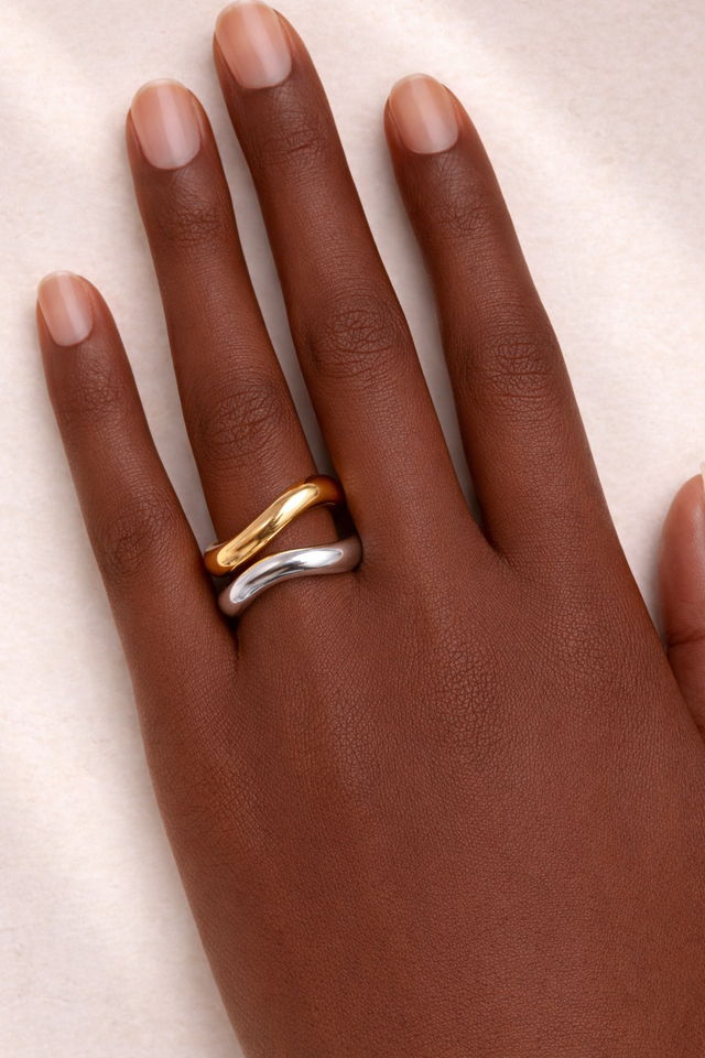 Model wearing Kyma Vector mixed metal wave rings stacked on fingers