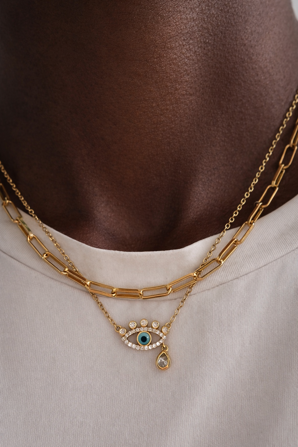 Gold large link chain layered with weeping evil eye necklace on model