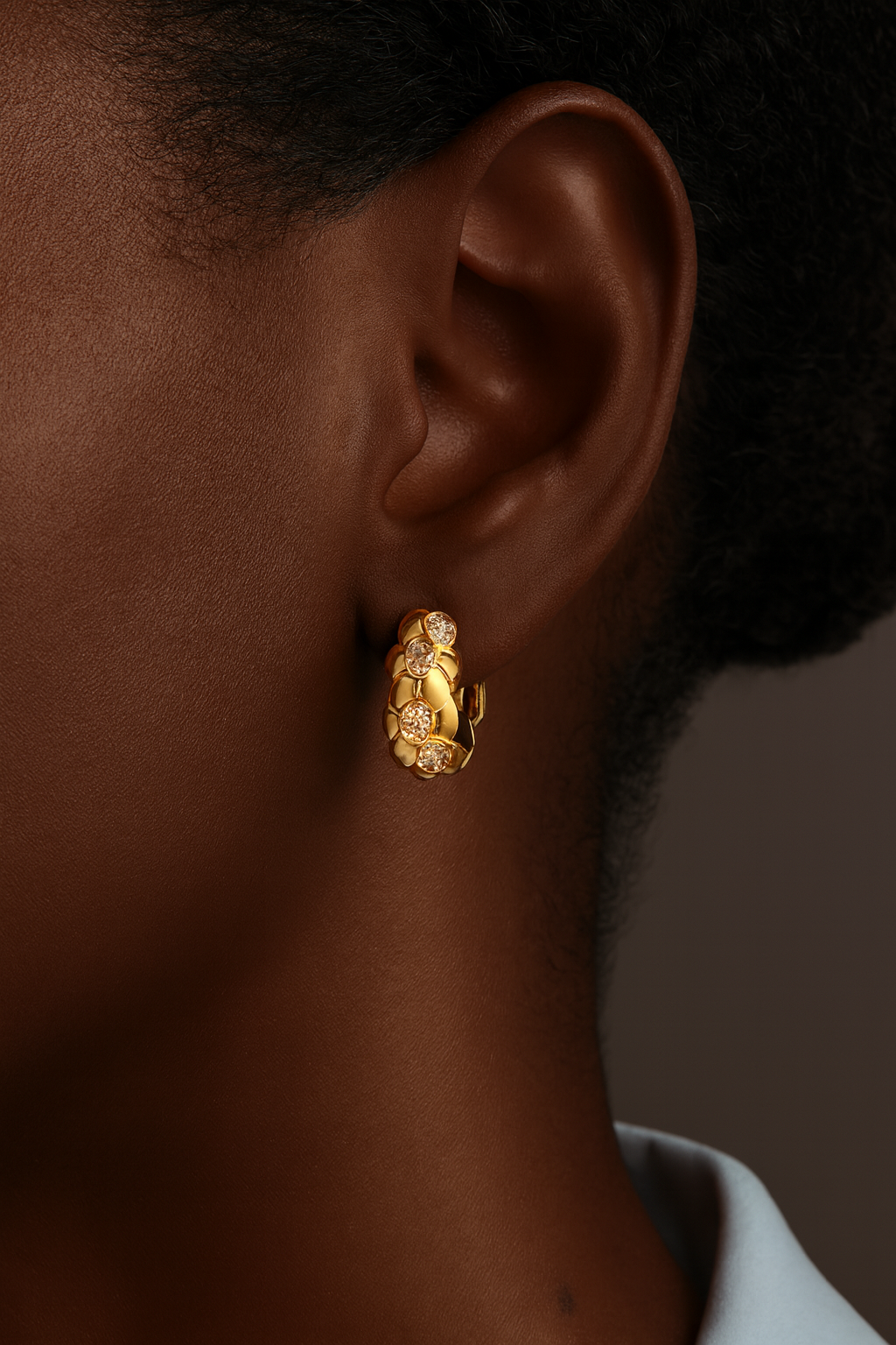 Model wearing the Leona Gold Huggie Earring — small 9mm gold hoop hugging the lobe, handcrafted in sterling silver and plated with 18ct gold by Galleria Armadoro.
