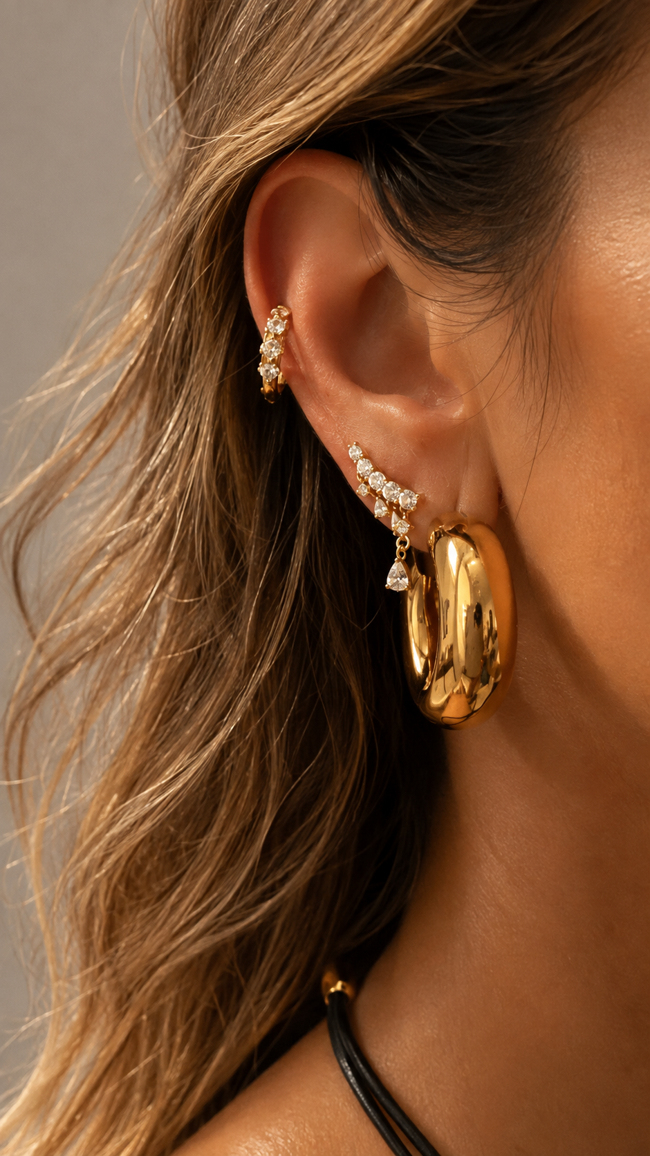 Gold ear stack by Galleria Armadoro featuring chunky Mini Darla Hoops with delicate crystal earrings and ear jewellery.