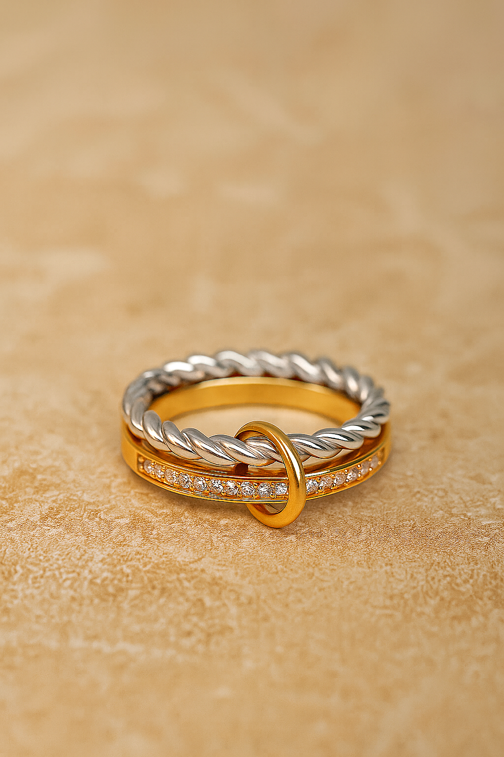Flat lay of two-tone Livia ring showing silver rope band linked with gold pavé bar.