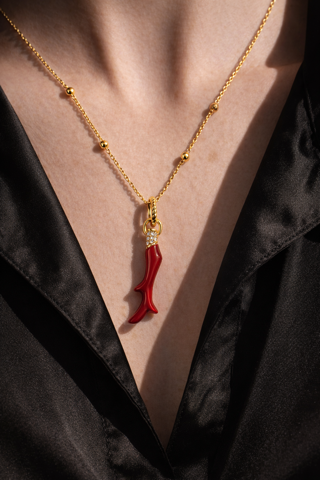 Model wearing Speira red coral gold vermeil necklace on the neckline, 18ct gold plated charm with CZ pavé on Charlotte chain