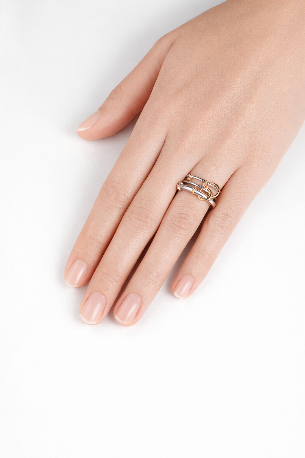 Modern linked ring worn on hand, mixed metal silver and gold