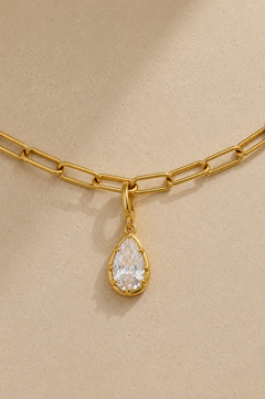 Close-up of Vittoria gold teardrop crystal charm attached to gold paperclip chain