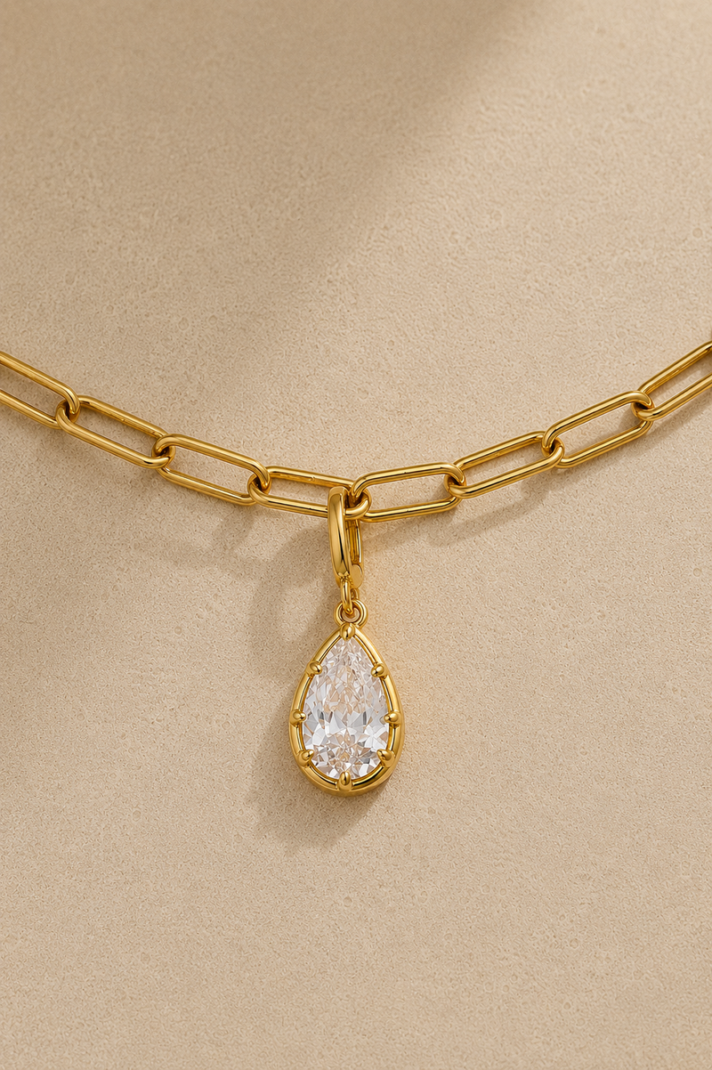 Close-up of Vittoria gold teardrop crystal charm attached to gold paperclip chain