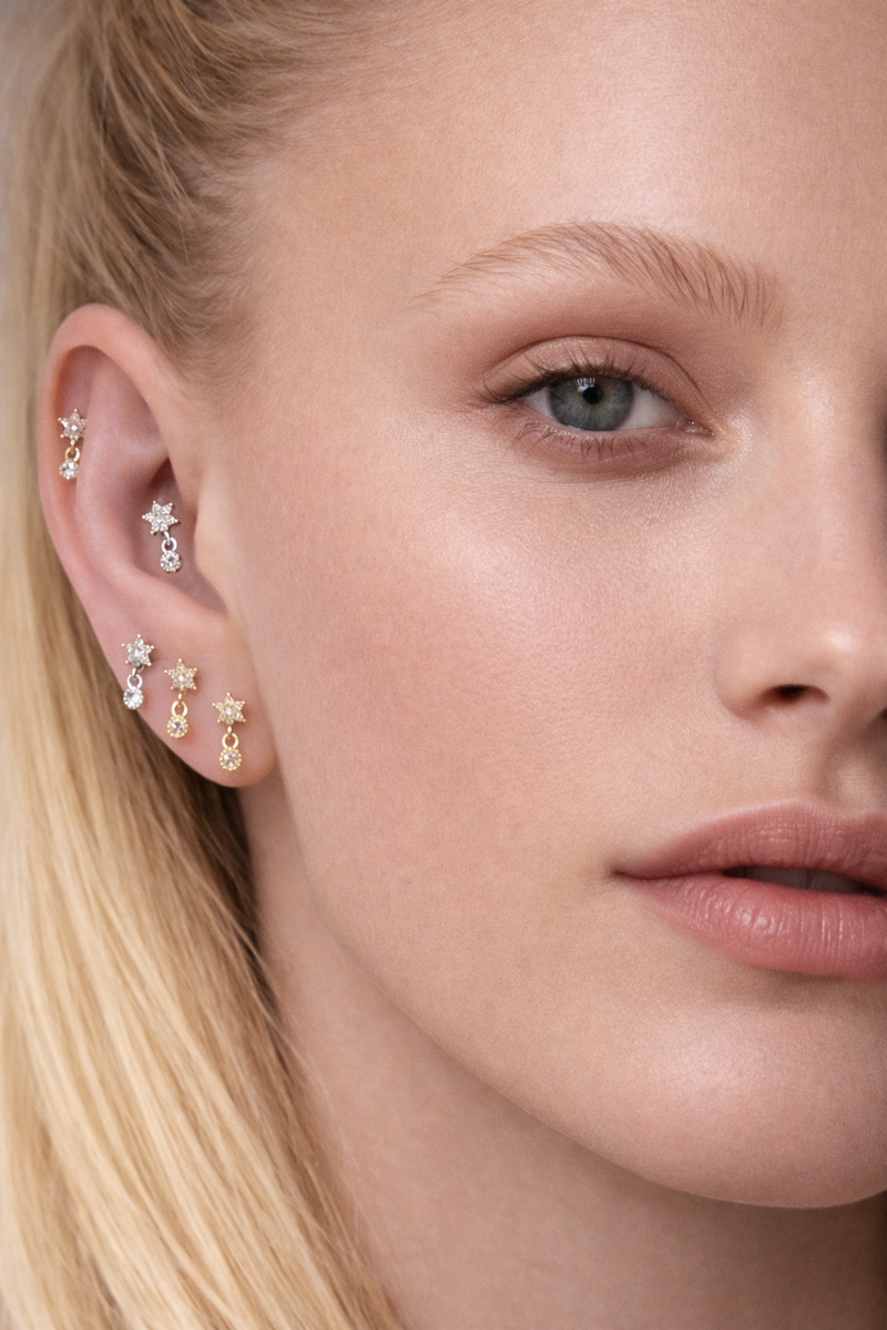 Ear piercing stack styling with Romy stud in gold, second lobe piercing and multiple earring placement ideas