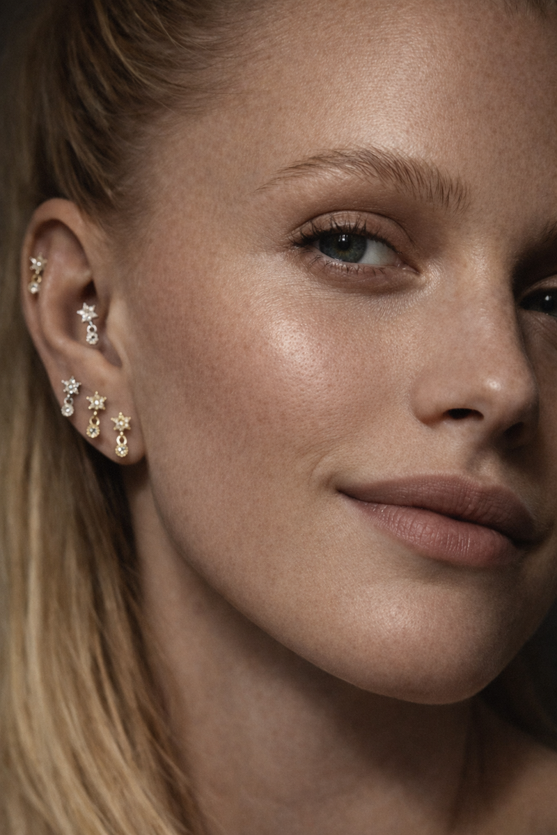 Close-up model wearing Romy Silver star drop stud in 2nd lobe piercing