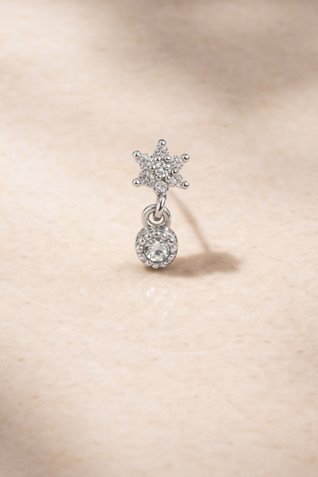 Romy Silver Star Drop Stud Earring in 925 sterling silver with white rhodium plating on beige marble background