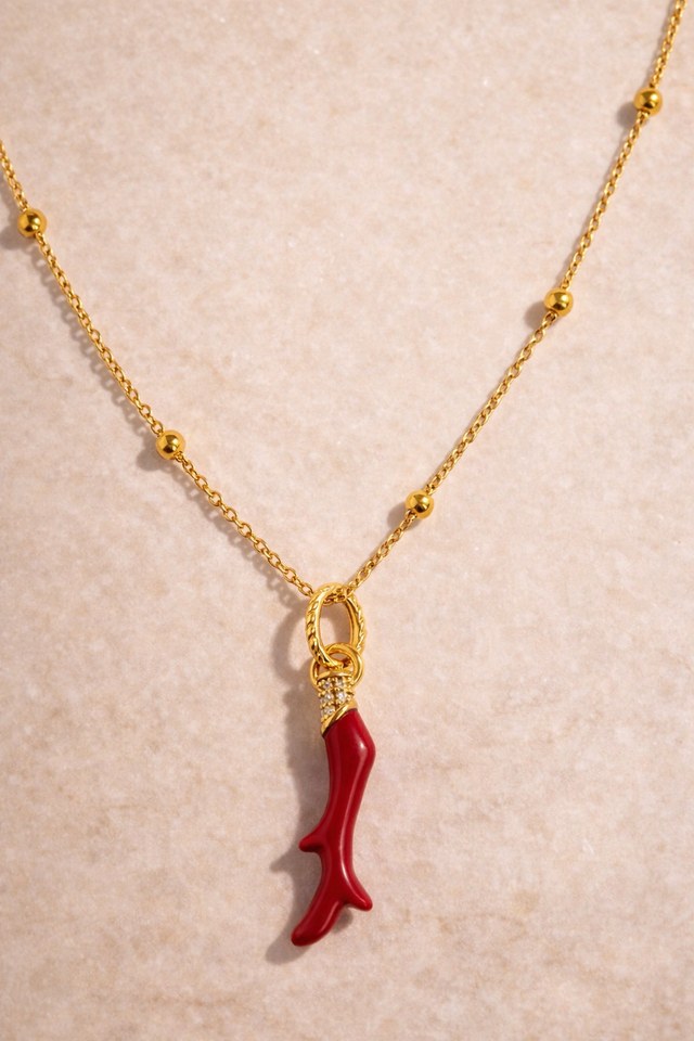 Speira red coral gold vermeil necklace with 18ct gold plated sterling silver charm and CZ pavé on Charlotte beaded chain, studio photo on beige marble