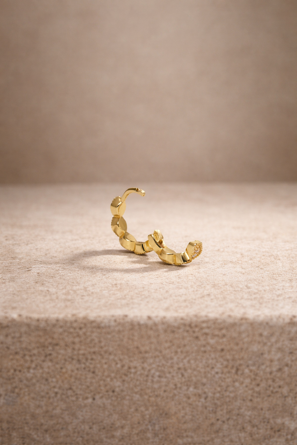 Tasha 8.5mm gold vermeil mini huggie hoop with row of white CZ stones, angled view -->