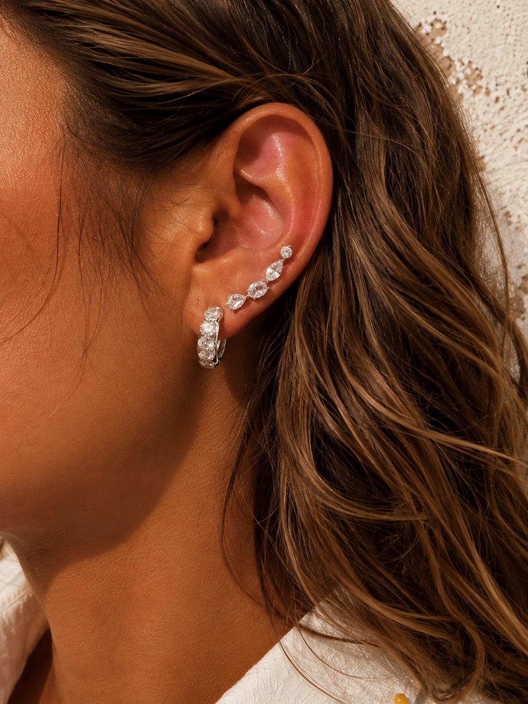 Silver ear stack by Galleria Armadoro featuring Daria and the Riviera Ear Climber, styled to create a layered look with fewer ear piercings.