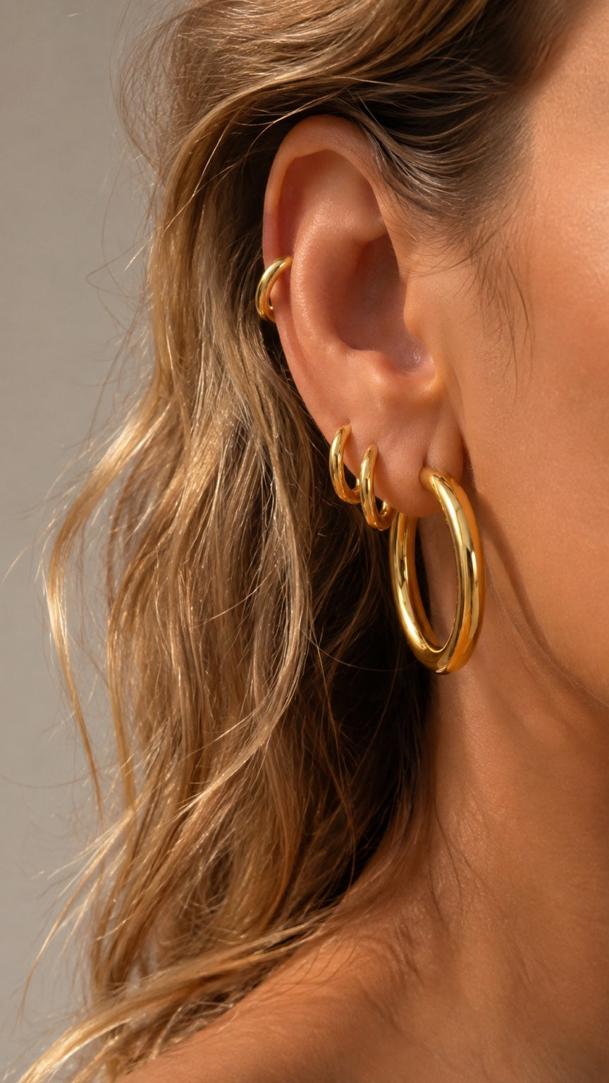 Graduated gold hoop ear stack by Galleria Armadoro featuring large and small gold hoops with a minimalist gold ear cuff.
