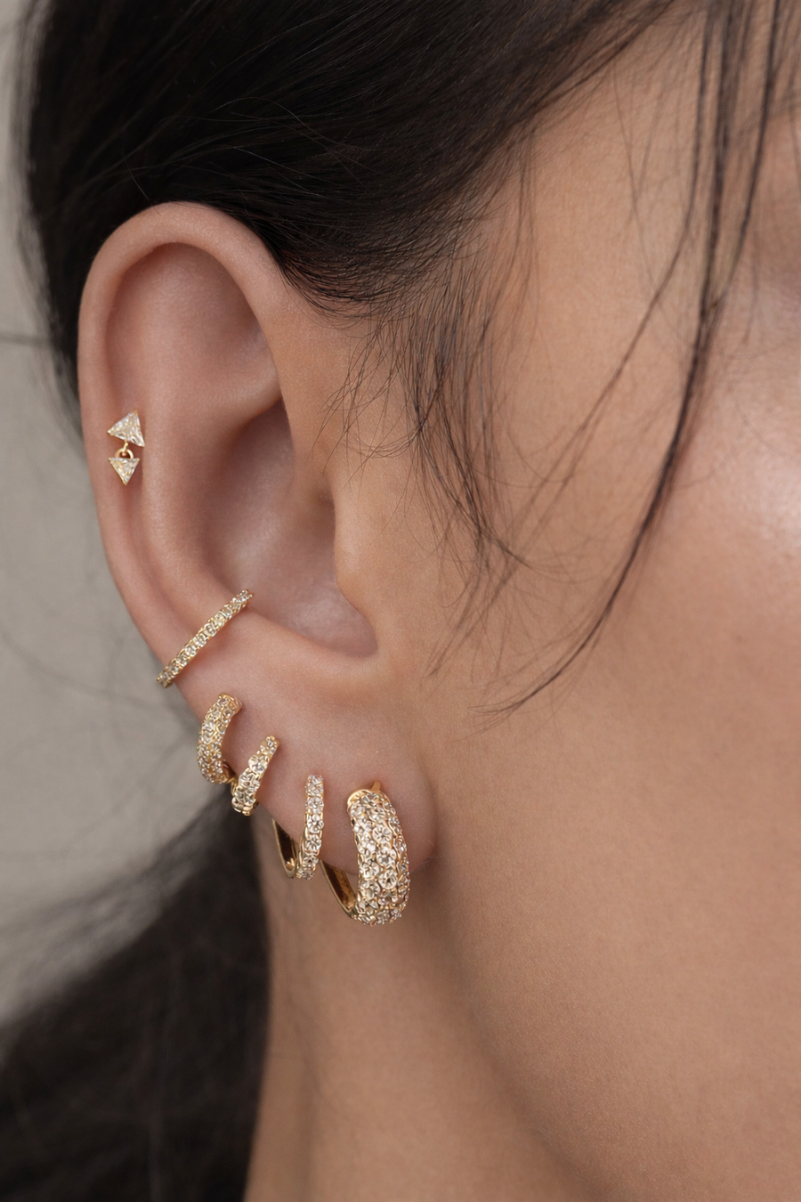 Gold ear stack by Galleria Armadoro featuring Speira, graduated huggies and a conch ear detail.