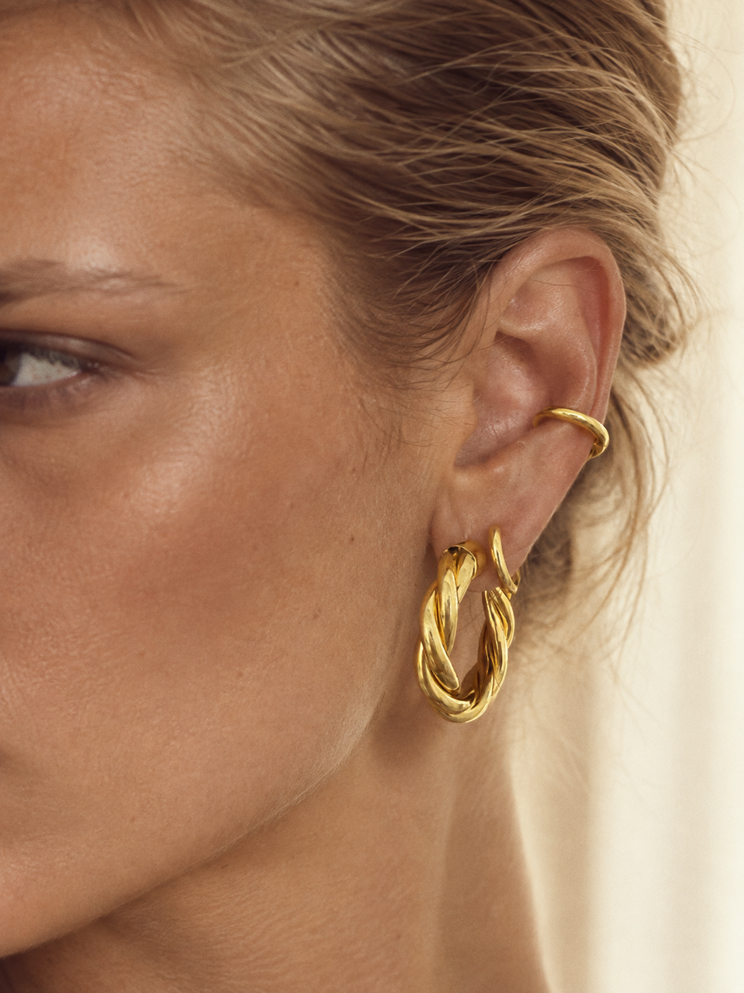 Graduated gold ear stack by Galleria Armadoro featuring Tina 3 cm hoops, an 8.5 mm second-piercing hoop and a 12 mm conch hoop.