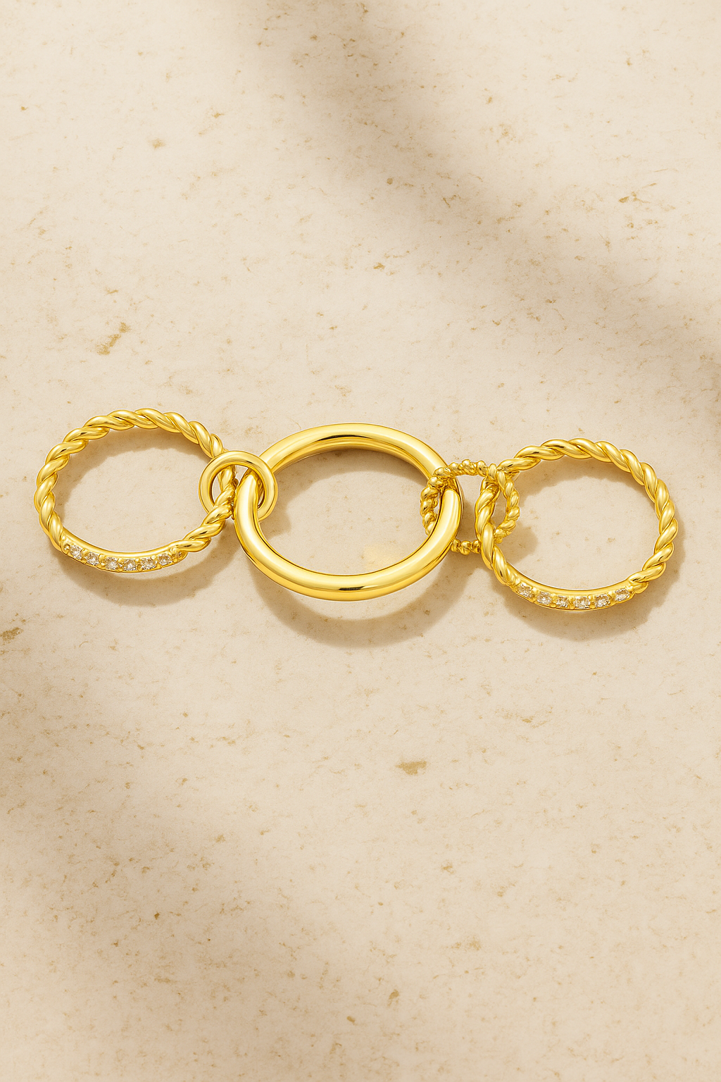 Hand wearing Carmella Speira triple-band gold ring with pavé bar and twisted rope details.