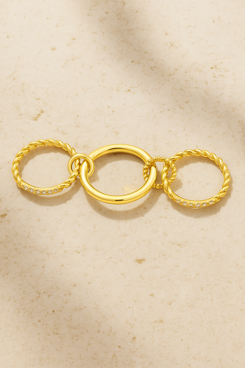Hand wearing Carmella Speira triple-band gold ring with pavé bar and twisted rope details.