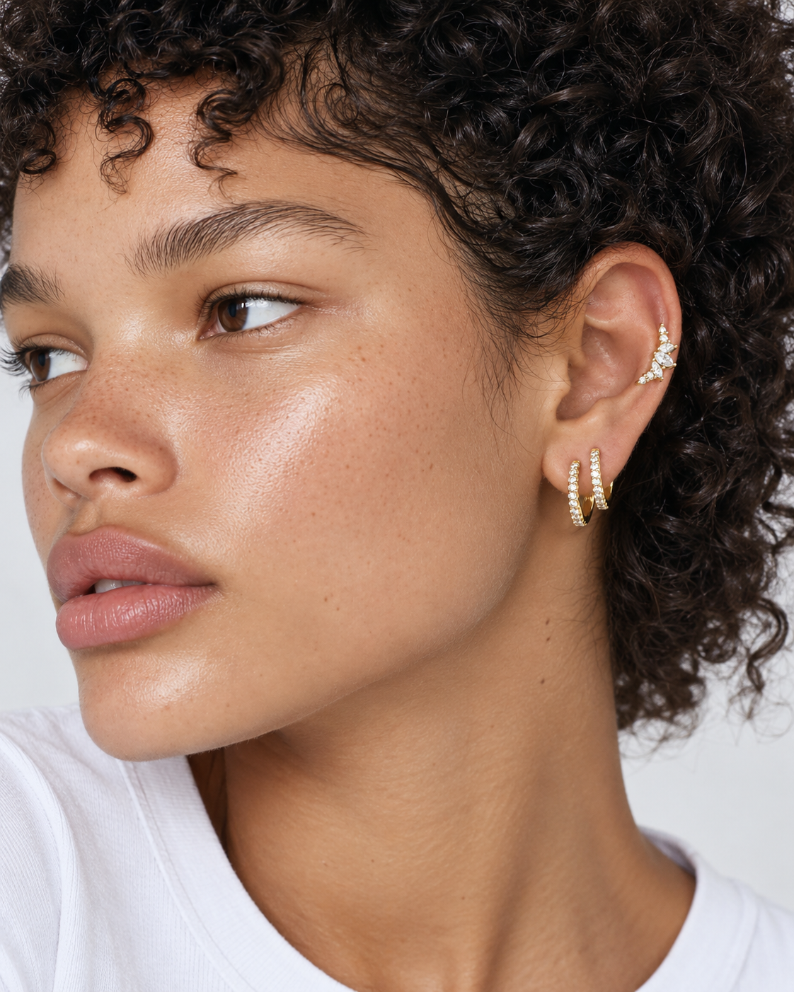 Second ear piercing idea by Galleria Armadoro featuring two stacked oval gold huggies and the Couronne mid helix earring.