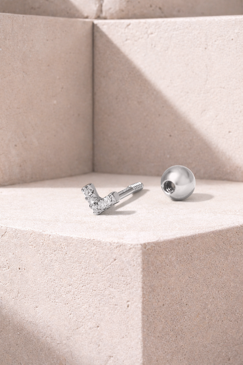 V-shaped silver stud earring shown unscrewed with threaded post and hollow ball screw backing