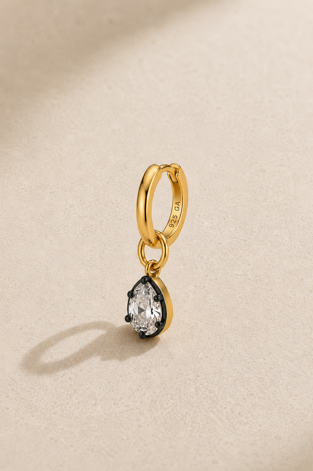 Close-up of 925 sterling silver gold-plated huggie earring with black rhodium Vittoria crystal charm