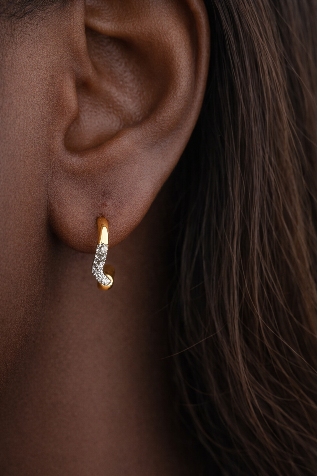 Amara Kyma mixed metal huggie earring worn in first lobe piercing on model