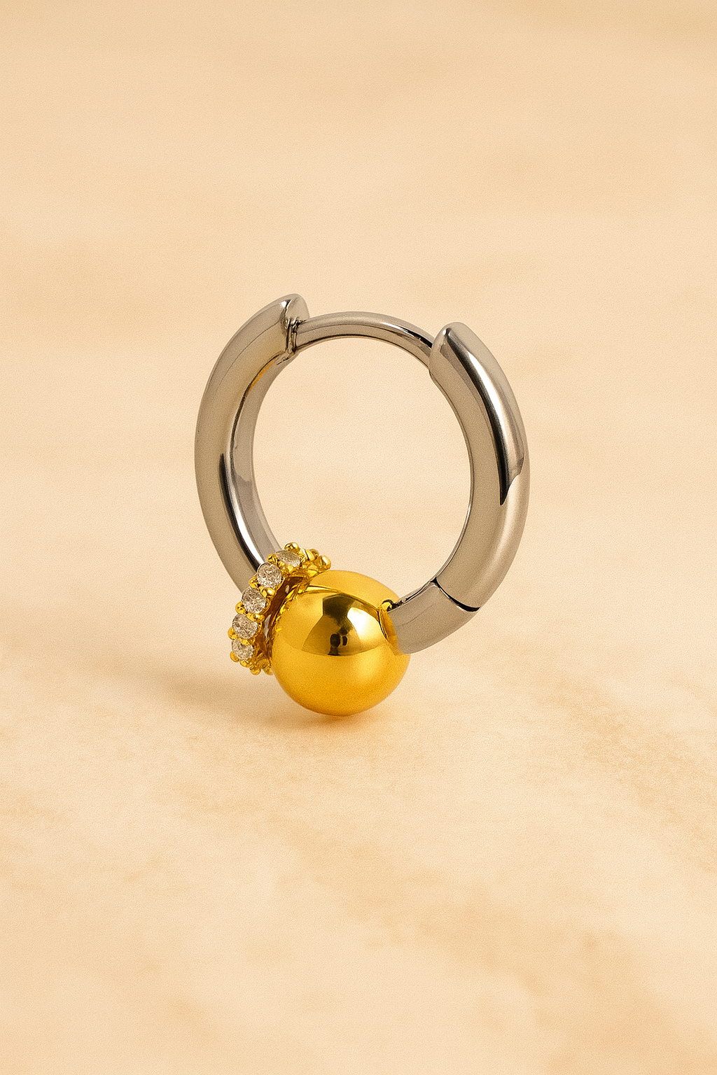 Macro detail of Kora bead huggie with all-around CZ halo and polished gold bead