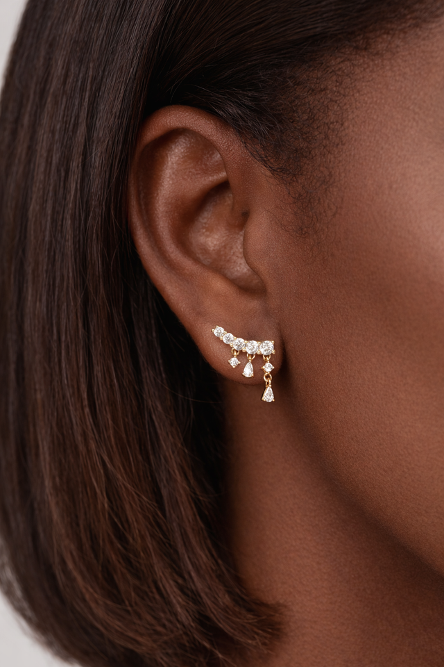 Drippy croissant gold vermeil stud earring worn on ear featuring cascading crystal drop design