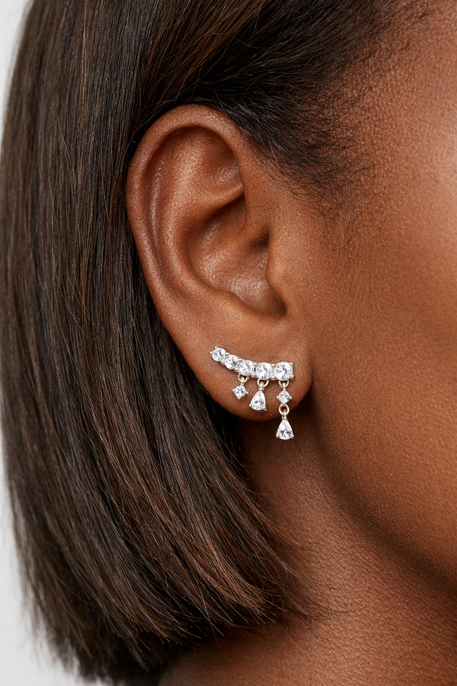 Drippy croissant sterling silver stud earring worn on ear featuring cascading crystal drop design